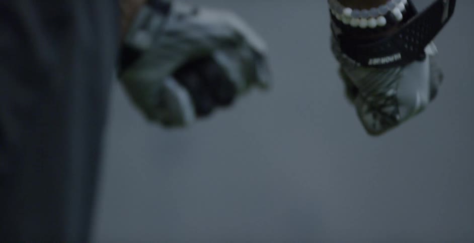 An athlete wearing gloves swings his arms as he gets set