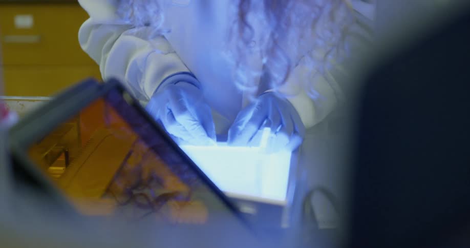 Woman wears gloves as she works on a slide