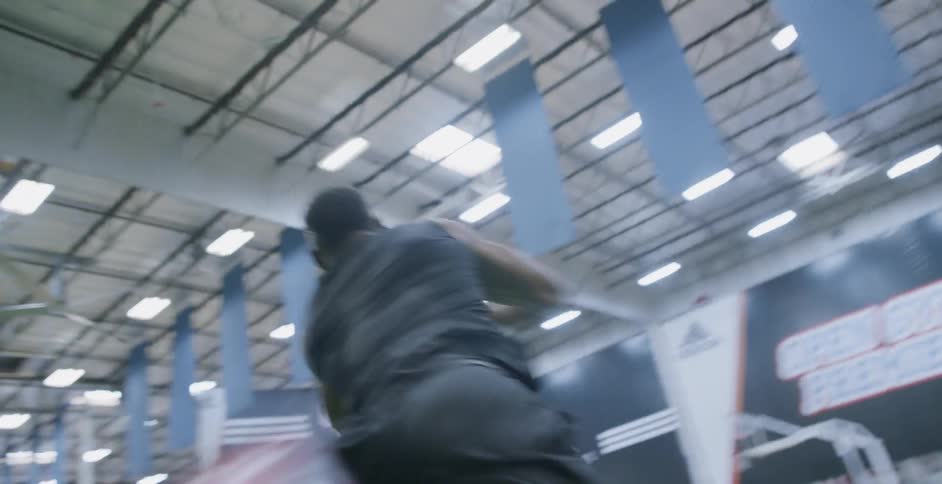 A man is running football drills in a gym