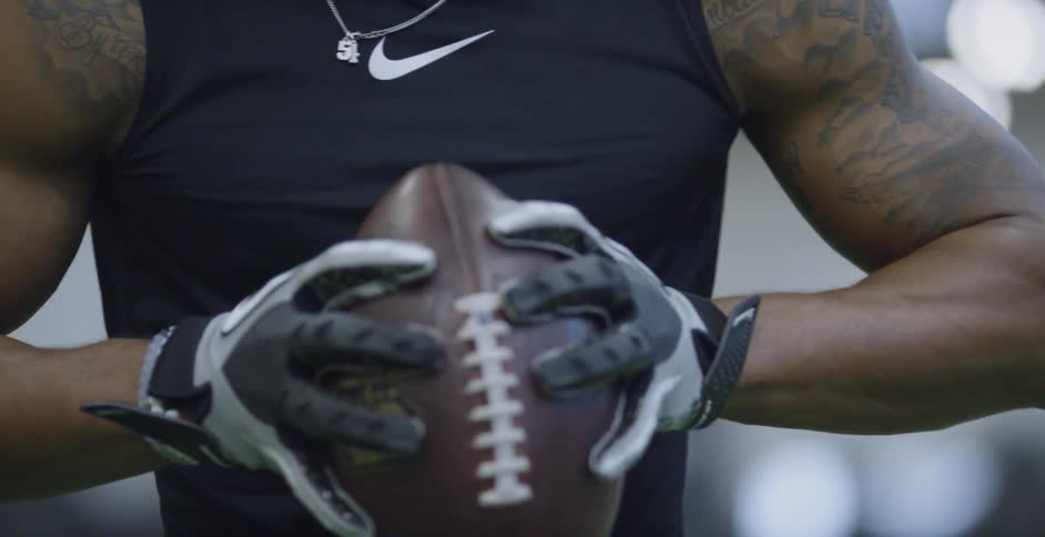 Man turns football in his hands getting ready to throw it