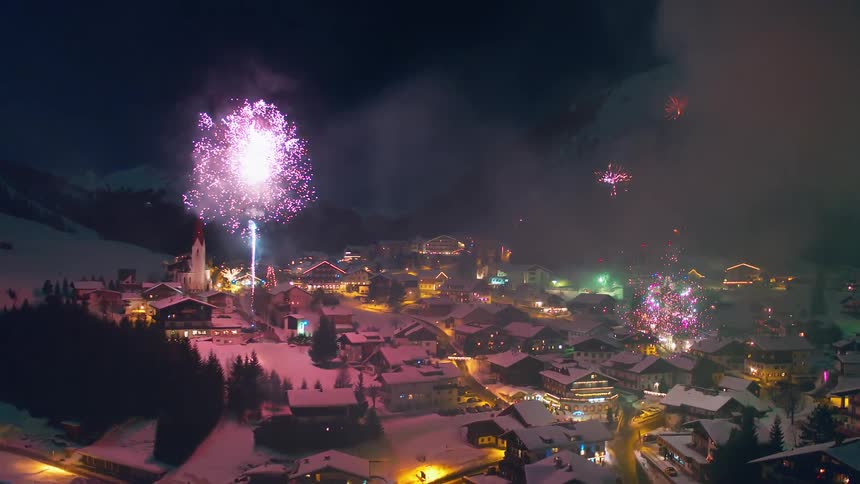 Fireworks explode above a snowy village