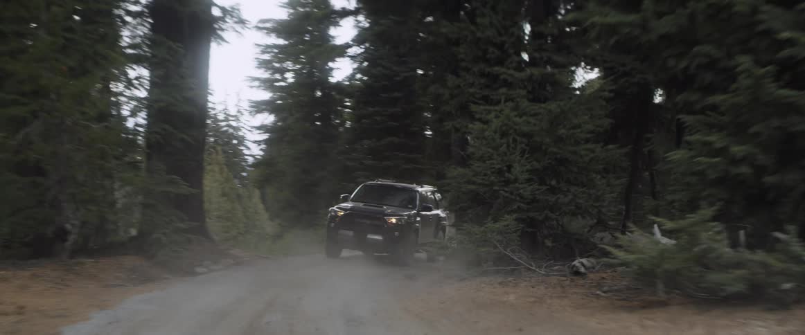 A truck drives on a dirt mountain road