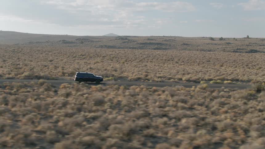 An suv travels on a desert road