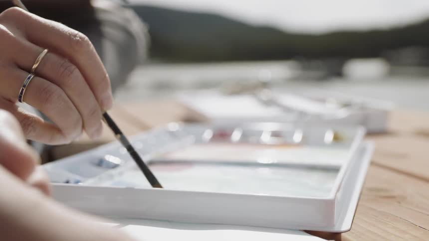 Person swirls a paintbrush in paint