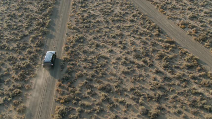 A truck drives on a dirt road