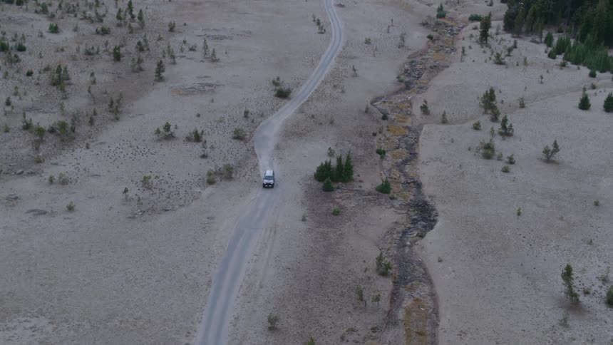 A truck drives on a dirt road