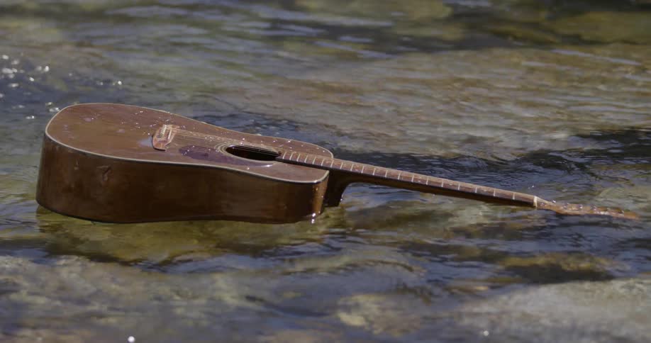 A guitar is floating down a small river