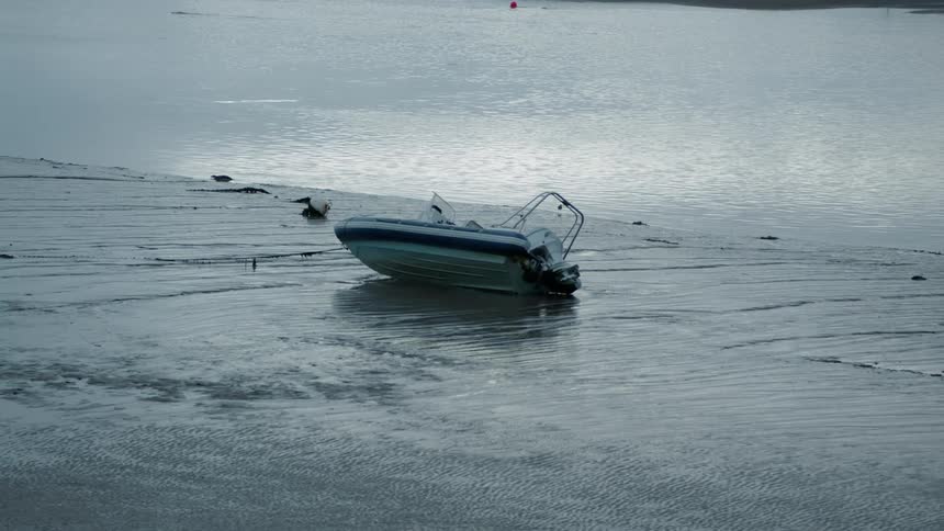 A boat is thrown on its side on a frozen section of water