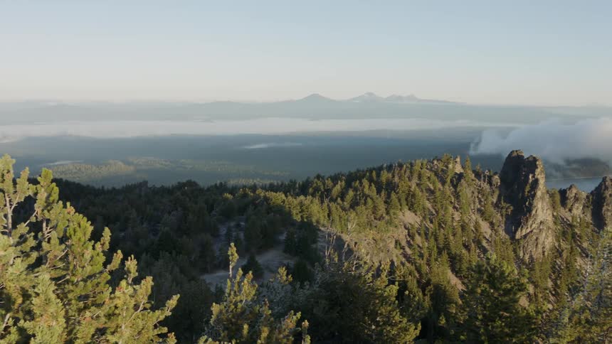 Mountains and trees sit under a blue sky