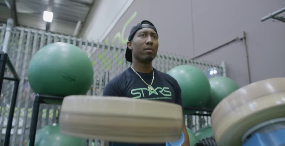 A man puts a football into a launcher for training