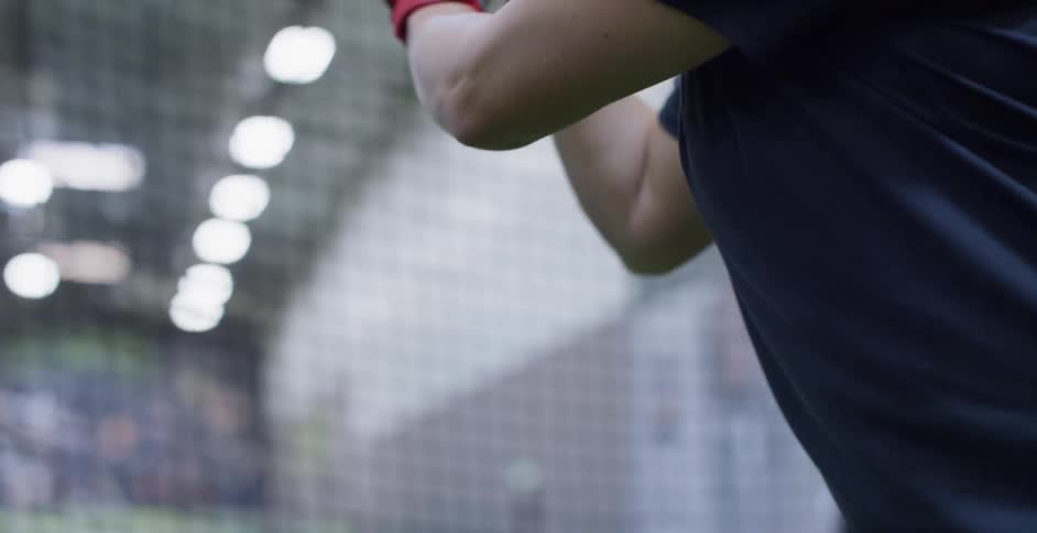Woman holds a baseball bat getting ready to hit a ball