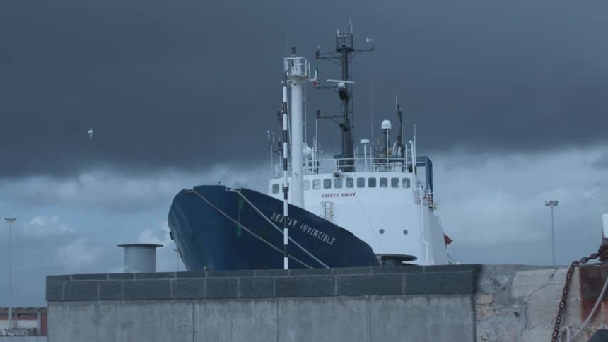 A large freighter boat sits docked in the water
