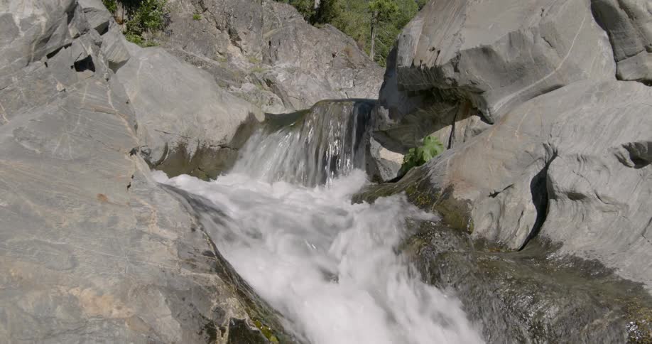 A guitar tumbles down rapids and off a waterfall