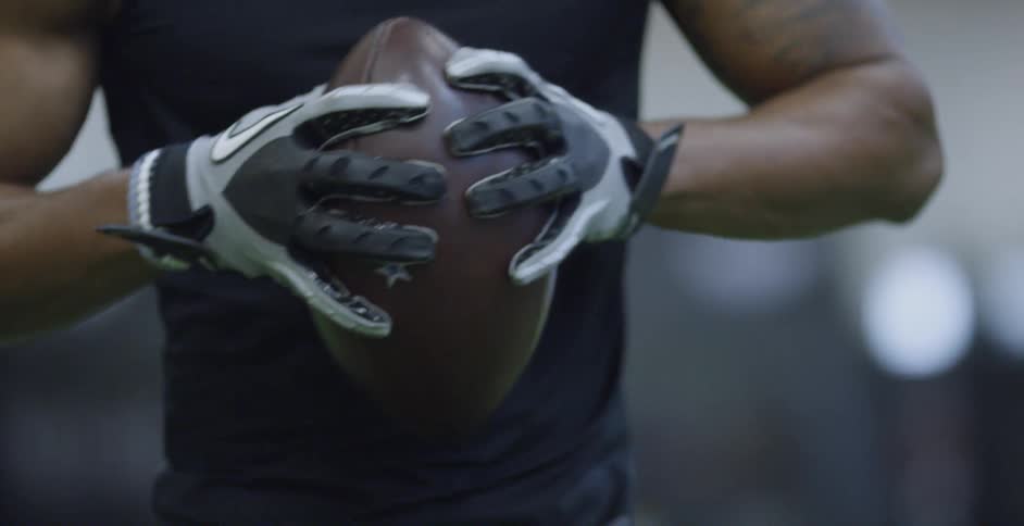 A football player squeezes the football