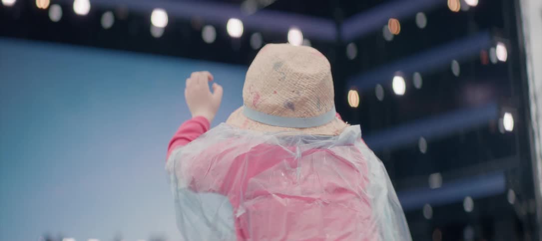 Someone is wearing a poncho and is enjoying a concert