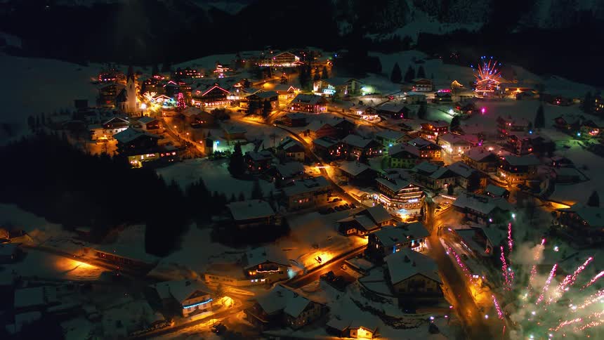 Fireworks go off at night in a snow covered village
