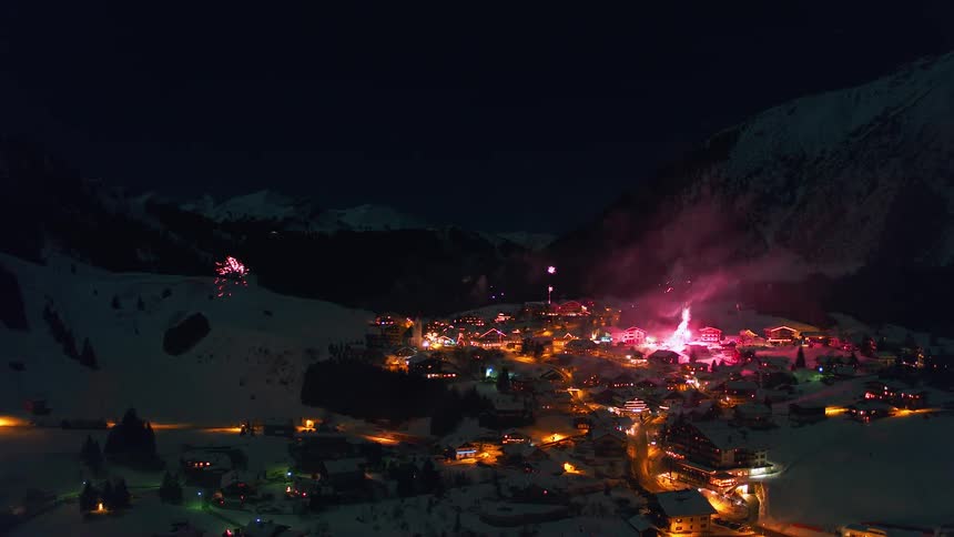 Fireworks explode above a snowy village