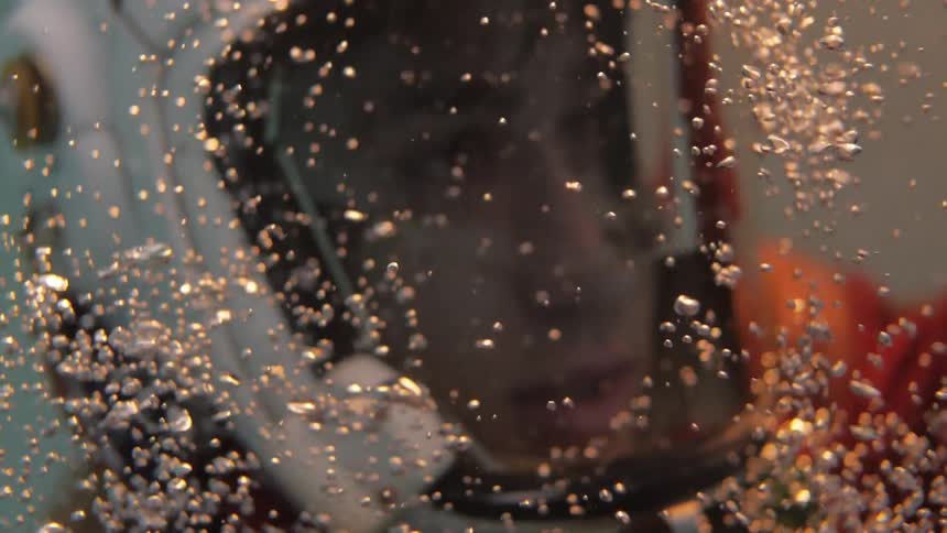 Man wearing helmet is underwater as his helmet fills with water