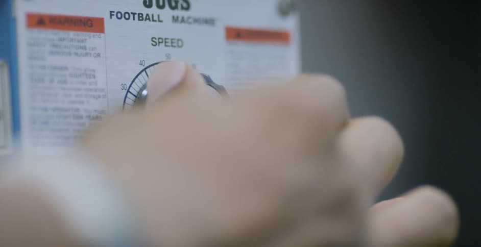 A person operates a football machine