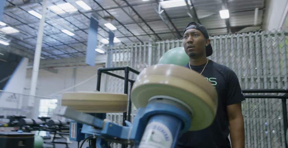 A man works the football launching machine in a sporting warehouse