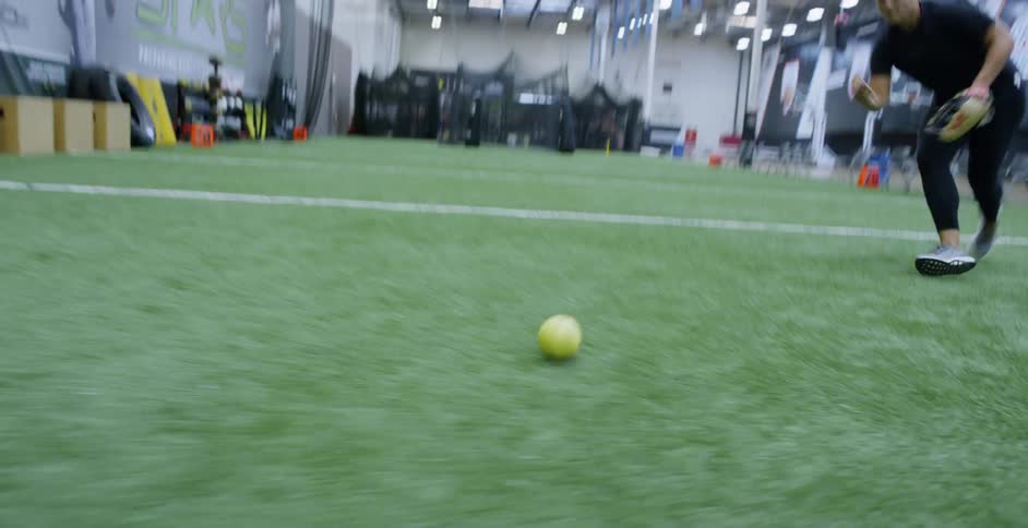 A woman plays softball on an indoor field