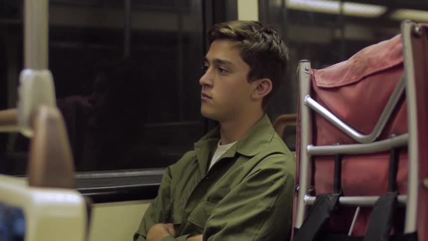 Man sitting on a train with his arms folded