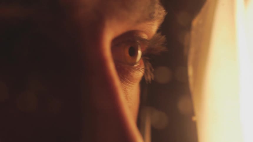 Man with eyes closed slowly opens them