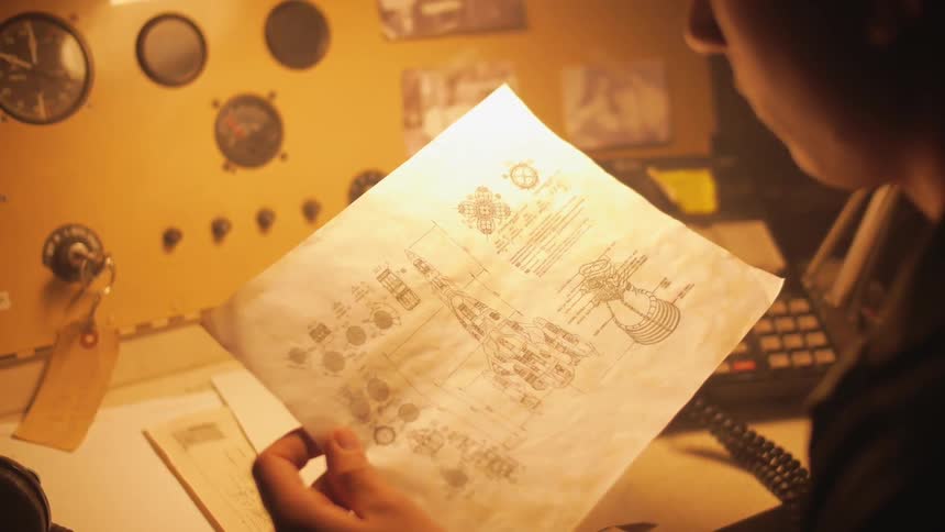 A person looks over blueprints