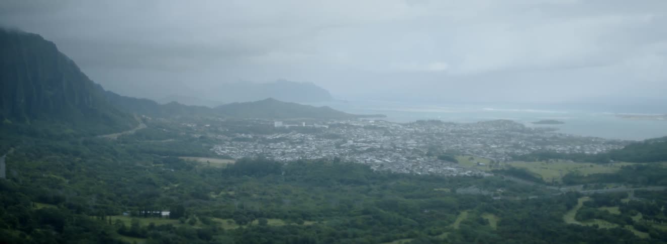 Clouds and fog are hanging over a coastal town during the day