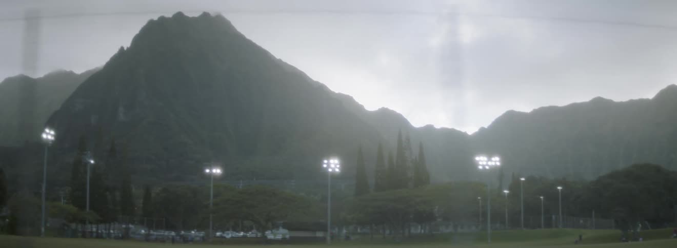 Athletic field standing before mountains on a cloudy sunset