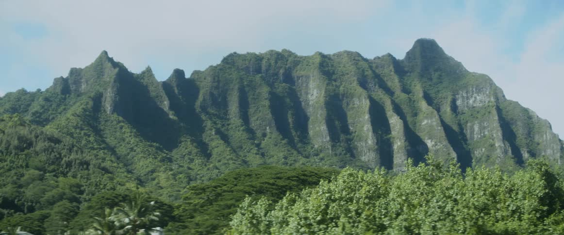 Grass and trees cover the rocky cliffs