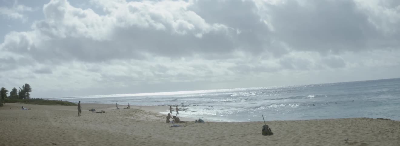 People walk and recline on a beach
