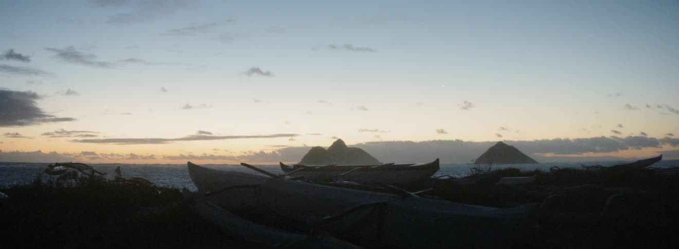 Boats sit on the shore at sunset