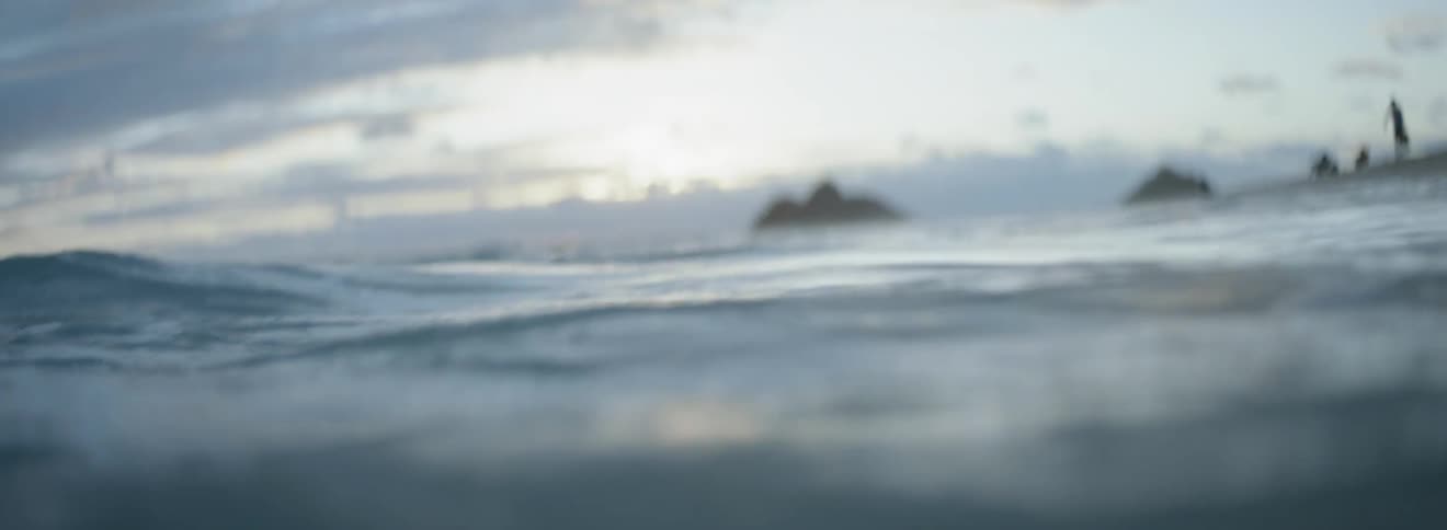 Waves are rising and falling in the ocean at dusk