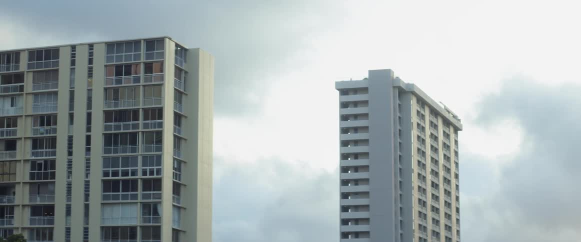 Two tall apartment buildings against a blue sky