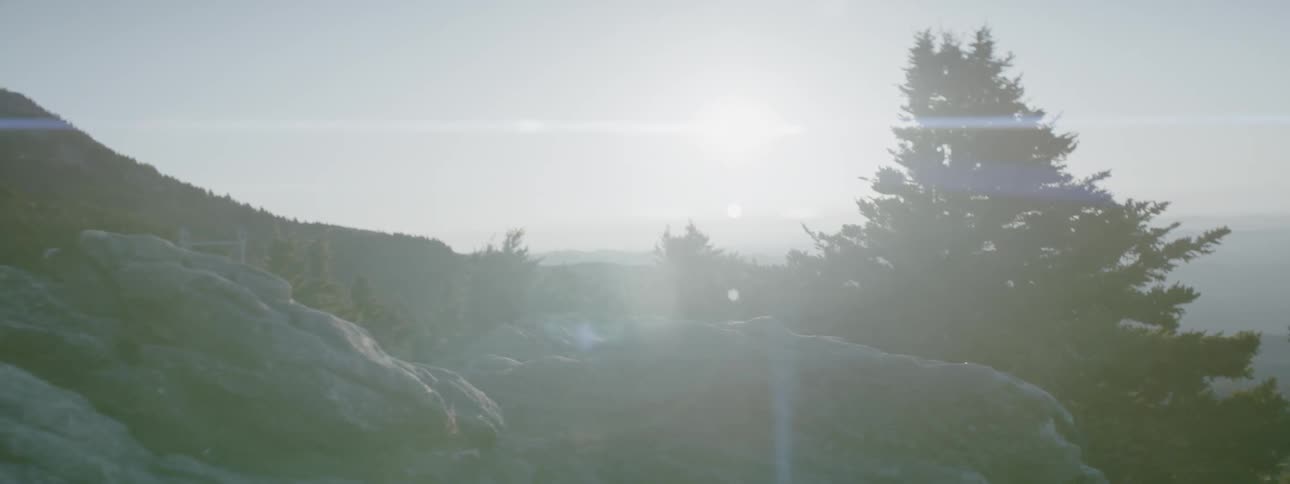 The sun shines brightly atop a tall hill