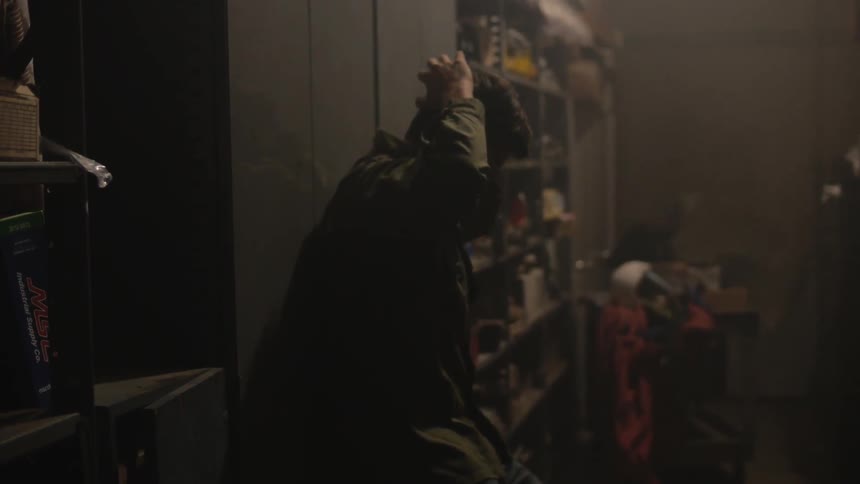 A man bangs on a cupboard and slides to the floor
