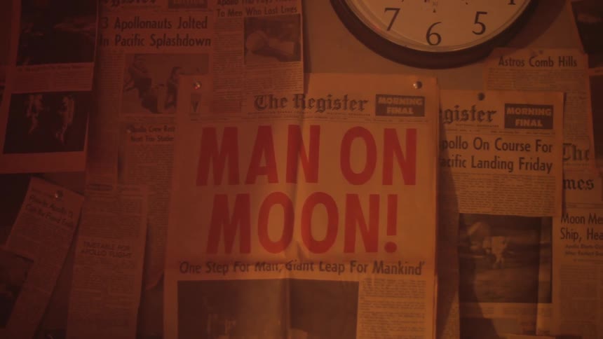 Wall covered with newspaper clippings and a clock in the center top