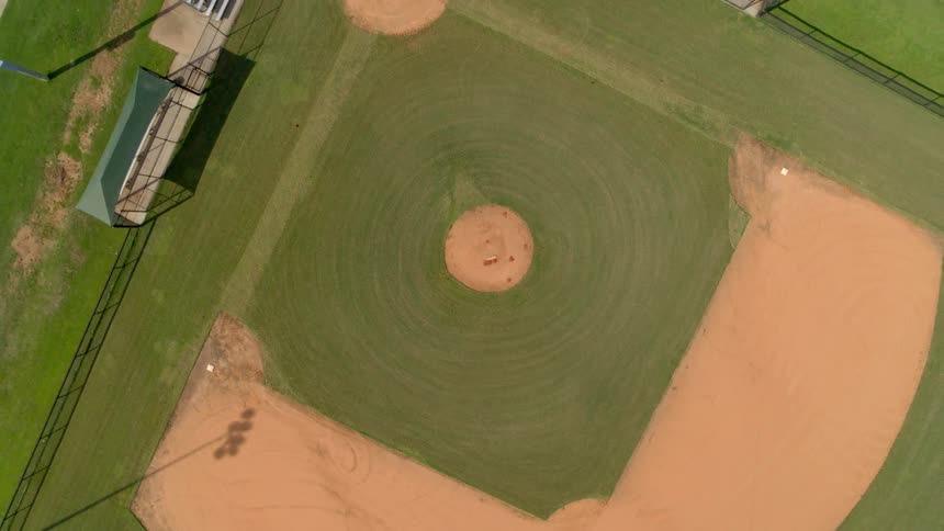 A pitcher's mound sits in the middle of an empty baseball field