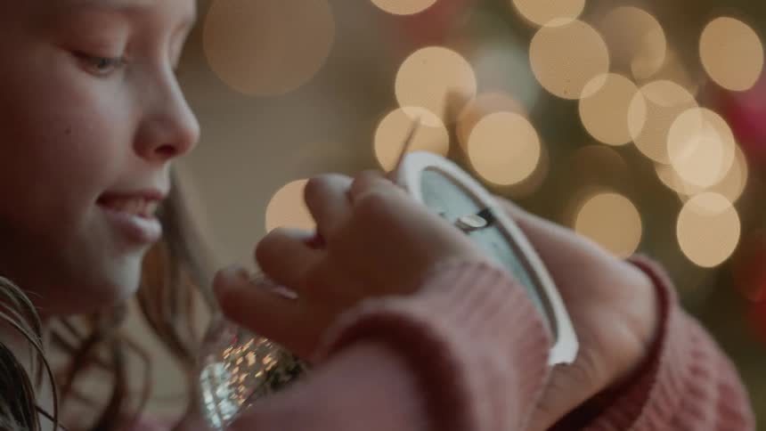 A girl is shaking a snow globe