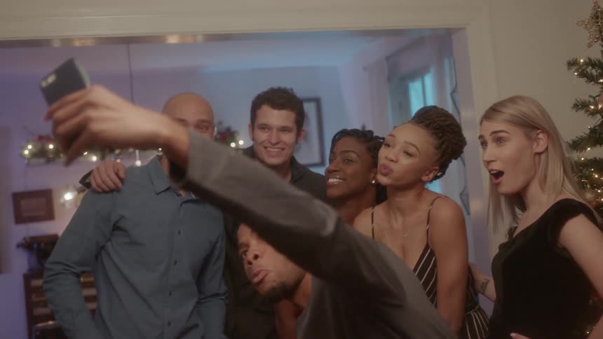 A group of friends are taking a selfie together in the living room