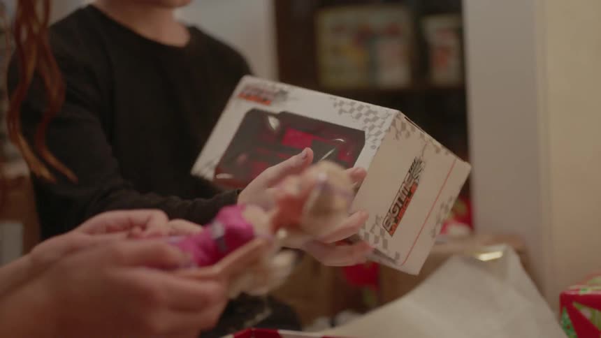 A girl and boy open christmas gifts