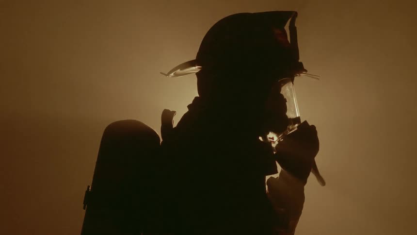 Firefighter attaches oxygen filter to face mask
