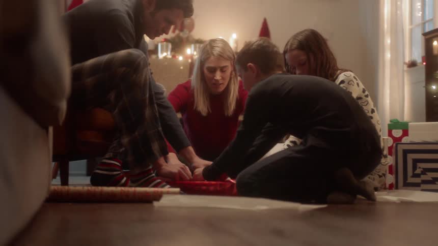 A family wraps a christmas gift