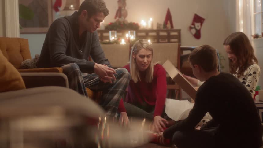 A family is sitting around opening presents on christmas morning