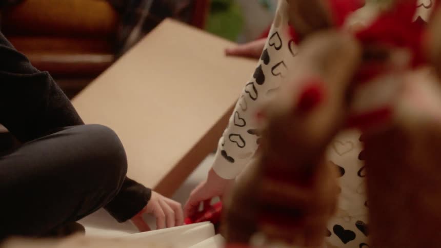 A family wraps a christmas gift