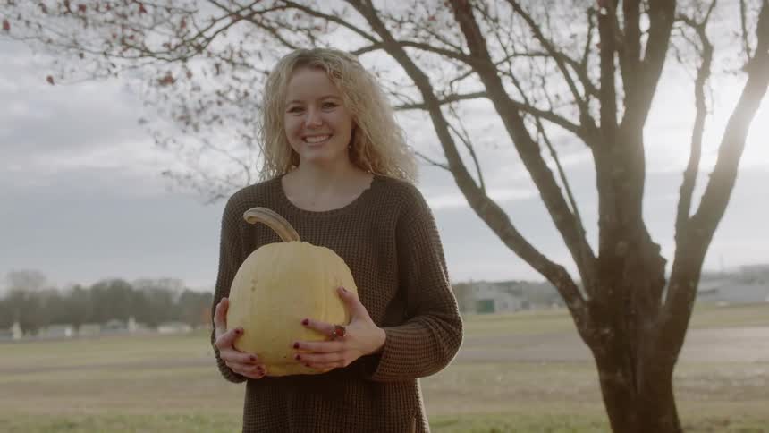 Woman holds pumpkin