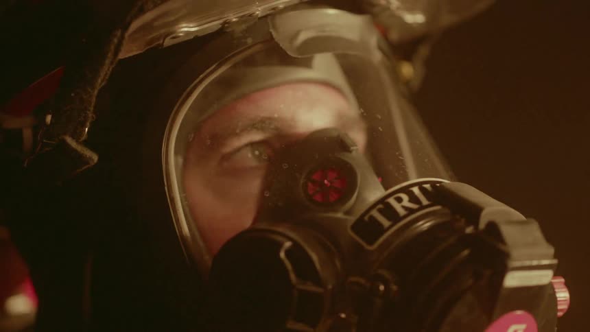A firefighter wears a mask near a fire