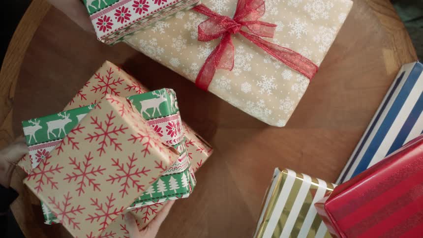 People grab christmas presents from a table