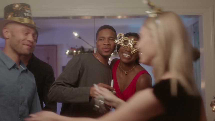 A group of friends are celebrating the new year together in a living room